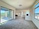 Open-concept living room with large windows and a sliding glass door to a balcony at 10879 Artesano Ave, Las Vegas, NV 89135