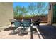 Outdoor patio area with a table, chairs, brick pavers, and view of the landscaping at 10879 Artesano Ave, Las Vegas, NV 89135