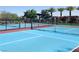 Community pickleball court featuring colorful surface, black fencing, and mature trees creating a great recreational amenity at 10879 Artesano Ave, Las Vegas, NV 89135