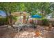 Backyard featuring brick pavers, seating, mature trees, and privacy walls at 1115 Melville Dr, Las Vegas, NV 89102