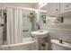Bathroom with tub/shower combination, pedestal sink, and ceramic tile up the walls at 1115 Melville Dr, Las Vegas, NV 89102