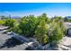 A home's front yard with mature trees, a white picket fence, and mountain views in the distance at 1115 Melville Dr, Las Vegas, NV 89102