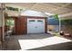 Two-car garage showcasing a white door, brick exterior, with a covered driveway, providing secure parking at 1115 Melville Dr, Las Vegas, NV 89102