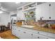 Well-lit kitchen with white cabinets, granite counters, brick backsplash, and stainless steel appliances at 1115 Melville Dr, Las Vegas, NV 89102