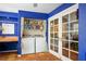 Bright laundry room with washer, dryer, storage shelving, and access to backyard at 1115 Melville Dr, Las Vegas, NV 89102