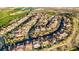 Panoramic aerial view of a neighborhood featuring well-kept homes, winding streets, and scenic desert landscape at 1223 Casa Palermo Circle Cir, Henderson, NV 89011