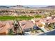 High aerial shot of a desert home with a red tile roof and desert landscaping in a golf course community with mountain views at 1223 Casa Palermo Circle Cir, Henderson, NV 89011