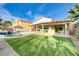 A spacious backyard showcasing a pool with a sun shelf and well-manicured artificial turf at 1223 Casa Palermo Circle Cir, Henderson, NV 89011