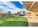 Serene backyard with a pool, artificial grass, covered patio, and mountain views at 1223 Casa Palermo Circle Cir, Henderson, NV 89011
