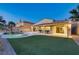 Spacious backyard offers a pool, lush green turf, covered patio, and desert landscaping at 1223 Casa Palermo Circle Cir, Henderson, NV 89011