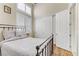 Comfortable bedroom with wood floors, high windows, closet doors, and a wrought iron bed at 1223 Casa Palermo Circle Cir, Henderson, NV 89011