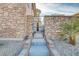The stone accented front gate leads to the home's entrance with desert landscaping at 1223 Casa Palermo Circle Cir, Henderson, NV 89011