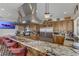 Spacious kitchen boasts stainless steel appliances, custom cabinets, granite countertops, and breakfast bar seating at 1223 Casa Palermo Circle Cir, Henderson, NV 89011