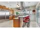 Bright kitchen featuring wood cabinets, stainless steel appliances, an island with seating and large window at 1223 Casa Palermo Circle Cir, Henderson, NV 89011