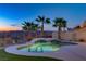Inviting backyard pool and spa with palm trees silhouetted against a colorful twilight sky at 1223 Casa Palermo Circle Cir, Henderson, NV 89011