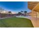Lush backyard showcases a pool, artificial turf and palm trees with a view of desert hills at 1223 Casa Palermo Circle Cir, Henderson, NV 89011