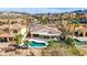 Aerial view of a home's backyard featuring a kidney-shaped pool, covered patio, and manicured landscaping in a desert community at 1223 Casa Palermo Circle Cir, Henderson, NV 89011