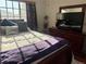 Cozy bedroom featuring wood floors, ceiling fan, a window with blinds, and a beautiful wood bedroom set at 2180 Polynesia Cir, Henderson, NV 89074