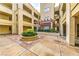 Detailed view of a courtyard with fountain, pergola, and manicured plants within a multi-story complex at 230 E Flamingo Rd # 203, Las Vegas, NV 89169