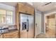 Kitchen with stainless refrigerator, built-in cabinets, and access to the hallway bathroom at 230 E Flamingo Rd # 203, Las Vegas, NV 89169