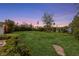 A spacious backyard with green lawn, landscaping, and a stone paver pathway at 2400 Llewellyn Dr, Las Vegas, NV 89102