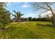 Spacious backyard with expansive lawn, mature trees and shrubs and blue sky at 2400 Llewellyn Dr, Las Vegas, NV 89102
