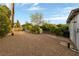 Gravel area featuring lush landscaping, mature trees, and a charming white picket fence at 2400 Llewellyn Dr, Las Vegas, NV 89102