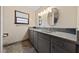 Bright bathroom features double sinks, sleek gray cabinets and modern fixtures and large framed mirrors at 2400 Llewellyn Dr, Las Vegas, NV 89102