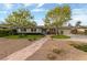 Charming single-story home with a landscaped front yard, stone walkway, and mature trees at 2400 Llewellyn Dr, Las Vegas, NV 89102