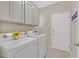 Laundry room featuring a front-load washer and dryer, upper cabinets, and neutral-colored walls at 2839 Goldcreek St, Henderson, NV 89052