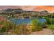 Scenic lake view of the waterfront community with charming architecture and lush landscaping at sunset at 29 Montelago Blvd # 131, Henderson, NV 89011