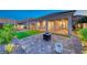 Lovely outdoor patio with a fire pit and seating, complemented by lush green grass and mature landscaping at 32 Tatahatso Point St, Henderson, NV 89011