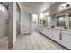 Elegant bathroom boasts double vanities, white marble floors, and a glass-enclosed shower at 32 Tatahatso Point St, Henderson, NV 89011