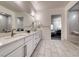 Bright bathroom featuring dual sinks, marble countertops, and a glass shower at 32 Tatahatso Point St, Henderson, NV 89011