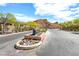 Community entrance with stone monument surrounded by desert landscaping and a mountain backdrop on a sunny day at 32 Tatahatso Point St, Henderson, NV 89011