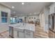 Open kitchen with large island, stainless steel appliances, and hardwood floors at 32 Tatahatso Point St, Henderson, NV 89011