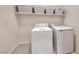 Functional laundry room equipped with a washer, dryer, and shelving at 32 Tatahatso Point St, Henderson, NV 89011