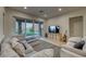 Cozy living room featuring a comfortable sofa, television, and sliding patio door at 32 Tatahatso Point St, Henderson, NV 89011
