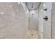 Luxurious shower showcasing marble-style tiling and a sleek glass enclosure at 32 Tatahatso Point St, Henderson, NV 89011
