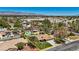Aerial view of a beautiful property featuring a well-manicured lawn, mature trees, and mountain views at 3361 Iberia St, Las Vegas, NV 89146