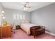 Cozy bedroom with a twin bed, wood furnishings, shutters, and soft pink carpet creating a comfortable and relaxing space at 3361 Iberia St, Las Vegas, NV 89146