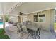 Covered patio with outdoor dining set, ceiling fan, and views of the backyard and pool create a cozy entertaining space at 3361 Iberia St, Las Vegas, NV 89146