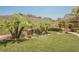Lush backyard featuring a serene waterfall, manicured lawn, and mature landscaping at 40 Stonemark Dr, Henderson, NV 89052