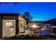 Charming backyard patio at dusk featuring a fire pit, BBQ area, and scenic views of the city below at 40 Stonemark Dr, Henderson, NV 89052