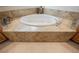 Close-up of a luxurious soaking tub with decorative stone surround at 40 Stonemark Dr, Henderson, NV 89052