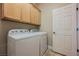 Laundry room featuring a front loading washer and dryer, tile floors, and overhead cabinets at 40 Stonemark Dr, Henderson, NV 89052