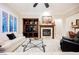 Comfortable living room featuring a fireplace, a custom built-in entertainment center, and large windows at 40 Stonemark Dr, Henderson, NV 89052
