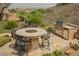 Outdoor kitchen area with grill, fire pit, and desert landscaping at 40 Stonemark Dr, Henderson, NV 89052