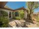 Secluded outdoor patio with stone tile, mature landscaping, and seating area at 40 Stonemark Dr, Henderson, NV 89052