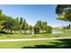 Scenic view of the golf course with a serene pond, lush fairways, and mature trees at 5341 E La Campana Dr, Pahrump, NV 89061